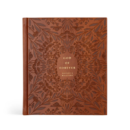 brown hard cover etched leather book with gold foil words in the middle that read "God of Forever by Haylee J Williams"