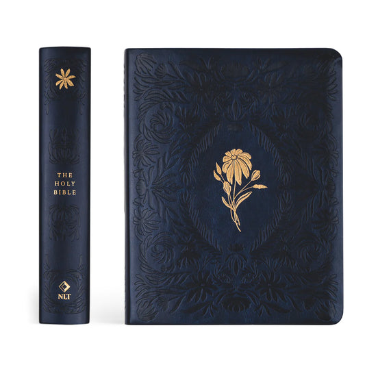 dark blue leather bible spine and front cover. both fully etched, the spine reads "The Holy Bible" in gold foil, the front has a flower in gold foil