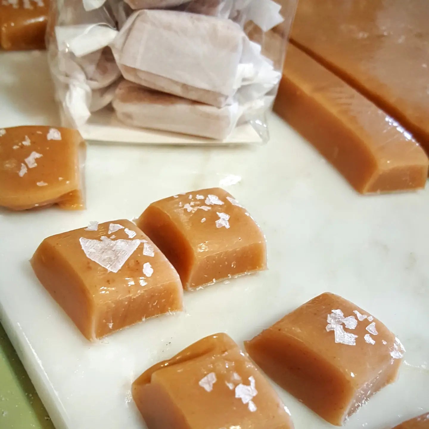 five fresh salted caramels topped with sea salt and small bag of wrapped caramels