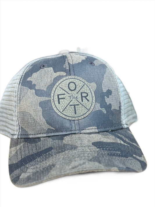 camo trucker hat with a round patch on front that says the FORT